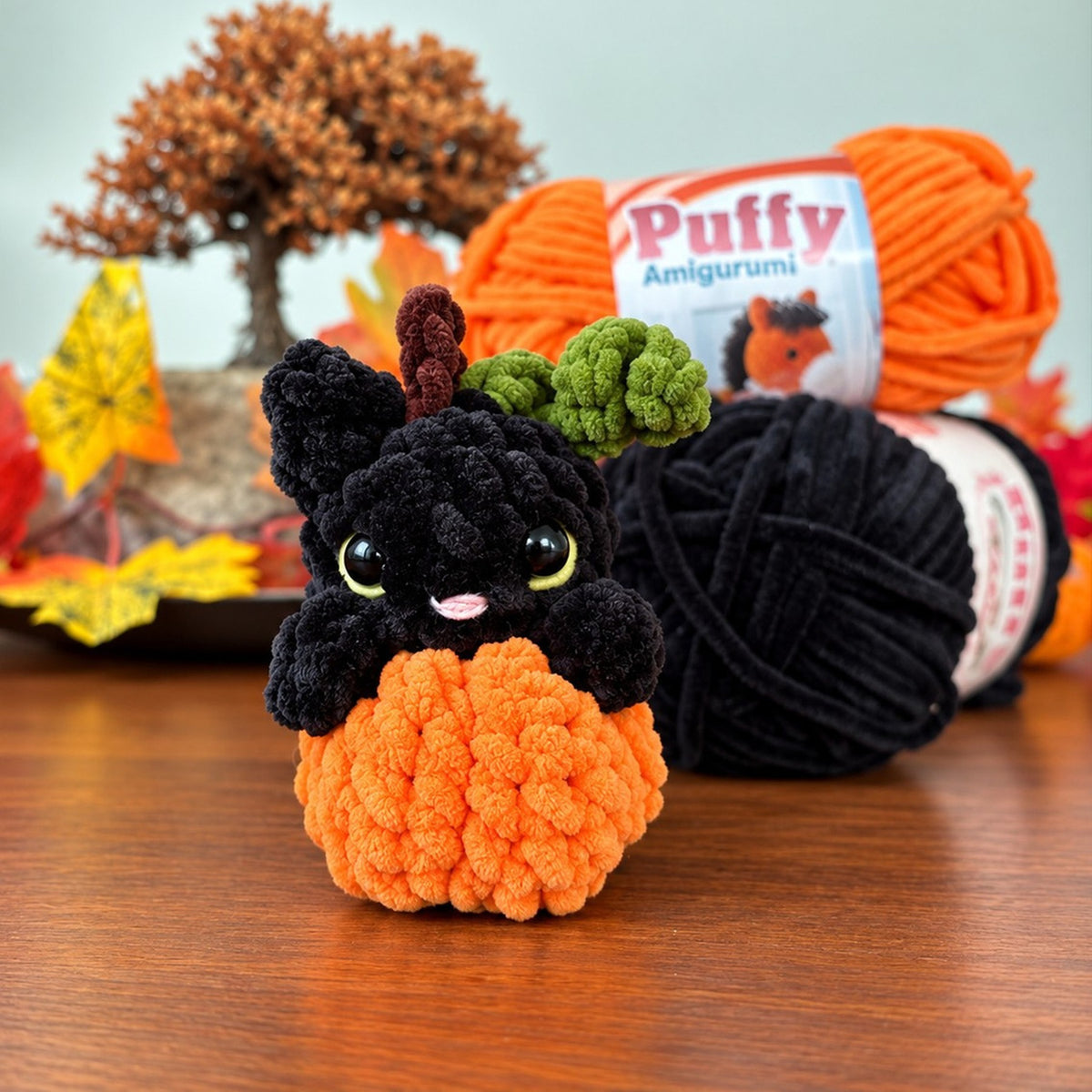 Salem con las bolas de Puffy Amigurumi negro y naranja y hojas de otoño